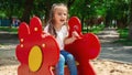 A cute little girl is playing in the children's yard. Healthy summer fun for kids. Child girl climbs down the street at the Royalty Free Stock Photo