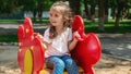 A cute little girl is playing in the children's yard. Healthy summer fun for kids. Child girl climbs down the street at the Royalty Free Stock Photo