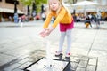 Cute little girl playing by city fountain on hot and sunny summer day. Child having fun with water in summer Royalty Free Stock Photo