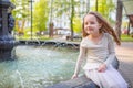 Cute little girl playing by city fountain on hot and sunny summer day. Child having fun with water in summer. Active leisure for k Royalty Free Stock Photo