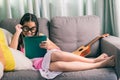 Cute little girl,playing with computer at home laying on sofa Royalty Free Stock Photo