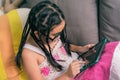 Cute little girl,playing with computer at home laying on sofa Royalty Free Stock Photo