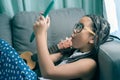 Cute little girl,playing with computer at home laying on sofa Royalty Free Stock Photo