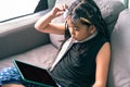 Cute little girl,playing with computer at home laying on sofa Royalty Free Stock Photo