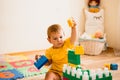 Little girl playing with construction toy blocks building a tower in a sunny kindergarten room Royalty Free Stock Photo