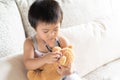 Cute little girl is playing doctor with stethoscope and teddy bear. Royalty Free Stock Photo