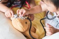 Cute little girl is playing doctor with stethoscope and teddy bear. Royalty Free Stock Photo