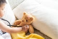 Cute little girl is playing doctor with stethoscope and teddy bear. Royalty Free Stock Photo