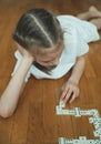 Cute little girl playing dominoes. Royalty Free Stock Photo