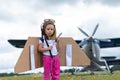 A cute little girl playing on the field by a four-seater private jet dreaming of becoming a pilot Royalty Free Stock Photo