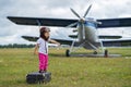 A cute little girl playing on the field by a four-seater private jet dreaming of becoming a pilot Royalty Free Stock Photo