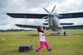 A cute little girl playing on the field by a four-seater private jet dreaming of becoming a pilot Royalty Free Stock Photo