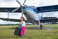 A cute little girl playing on the field by a four-seater private jet dreaming of becoming a pilot Royalty Free Stock Photo