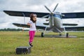 A cute little girl playing on the field by a four-seater private jet dreaming of becoming a pilot Royalty Free Stock Photo