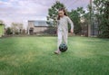 Cute little girl playing football with soccer ball on green lawn in backyard of house. Child kicking soccer ball on Royalty Free Stock Photo