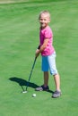 Cute little girl playing golf on a field Royalty Free Stock Photo