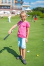 Cute little girl playing golf on a field outdoor Royalty Free Stock Photo