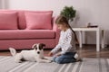 Cute little girl playing with her dog at home. Childhood pet Royalty Free Stock Photo