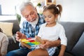 Cute little girl playing with her grandfather at home. Happy family concept Royalty Free Stock Photo