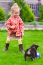 Cute little girl playing with her puppy in the yard Royalty Free Stock Photo