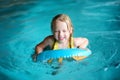 Cute little girl playing with inflatable ring in indoor pool. Child learning to swim. Kid having fun with water toys. Royalty Free Stock Photo