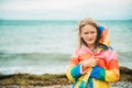 Cute little girl playing by the lake on a windy day Royalty Free Stock Photo