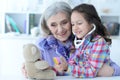 Cute little girl playing nurse, inspecting teddy bear