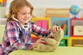 Cute little girl playing nurse, inspecting teddy bear with stethoscope