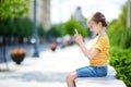 Cute little girl playing outdoor mobile game on her smart phone Royalty Free Stock Photo