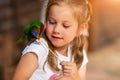 Cute little girl playing with a parrot and feed him Royalty Free Stock Photo