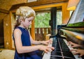 Cute little girl playing piano, dressing in retro Mozart periwig Royalty Free Stock Photo