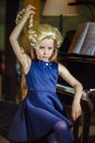 Cute little girl playing piano, dressing in retro Mozart periwig Royalty Free Stock Photo