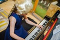 Cute little girl playing piano, dressing in retro Mozart periwig Royalty Free Stock Photo