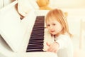 Cute little girl playing piano at a music school. Preschool child learning to play music instrument. Education, skills concept. Li Royalty Free Stock Photo