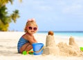 Cute little girl playing with sand on beach