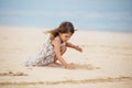 Cute little girl playing with sand on the beach in Dubai Royalty Free Stock Photo