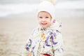 Cute little girl playing on the sandy beach. Happy child wearing Royalty Free Stock Photo