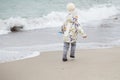 Cute little girl playing on the sandy beach. Happy child wearing Royalty Free Stock Photo