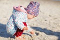 Cute little girl playing on the sandy beach. Happy child wearing Royalty Free Stock Photo