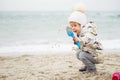 Cute little girl playing on the sandy beach. Happy child wearing Royalty Free Stock Photo