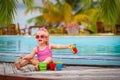 Cute little girl playing in swimming pool at tropical beach Royalty Free Stock Photo