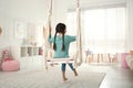 Cute little girl playing on swing at home Royalty Free Stock Photo