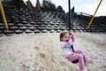 Cute little girl playing on a swing on the playground outdoors Royalty Free Stock Photo