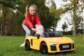 Cute little girl playing with toy bear and children`s car in park Royalty Free Stock Photo