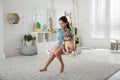 Cute little girl playing with toy deer on swing at home Royalty Free Stock Photo