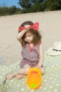 A cute little girl playing with a toy ship on the beach on a warm sunny summer day Royalty Free Stock Photo