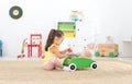 Cute little girl playing with toy walker and teddy bear at home Royalty Free Stock Photo