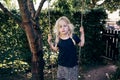 Cute little girl playing on a tree swing outdoors Royalty Free Stock Photo