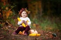 Cute little girl playing with vegetable marrow in autumn park. Autumn activities for children. Halloween and Thanksgiving time fun