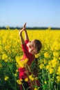 Cute little girl playing with yellow flowers in summer field. Happy child outdoors Royalty Free Stock Photo